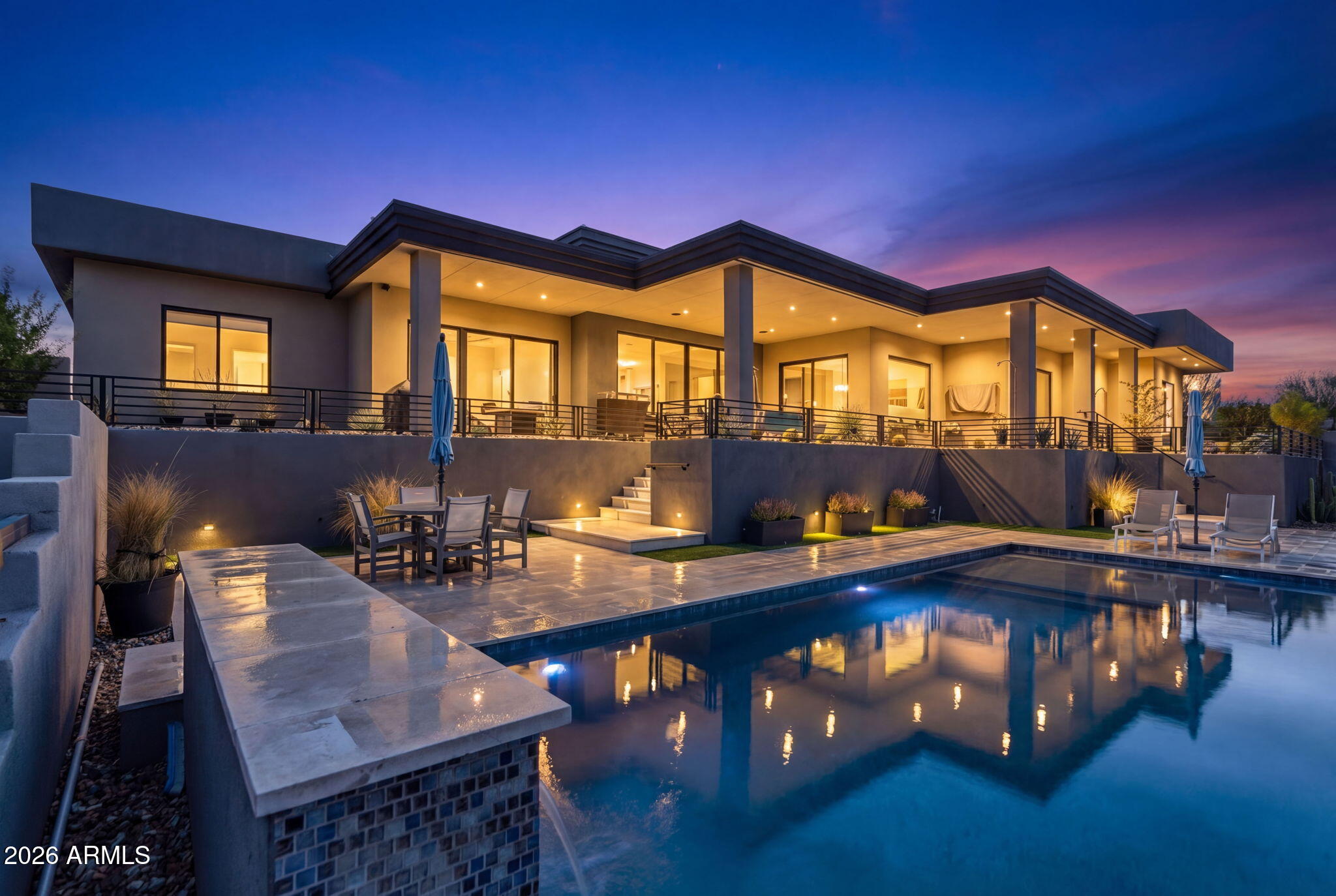 Perched on a stunning hillside in Fountain Hills, this exceptional custom home offers luxury living with breathtaking panoramic views of Fountain Hills, Painted Mountain, Four Peaks and the iconic fountain from nearly every window.
Step inside past your double glass custom door to soaring 16-foot ceilings in the living room and an open, light-filled floorplan designed for both everyday living and entertaining. The home is appointed with engineered hardwood flooring throughout and features a chef's dream kitchen featuring waterfall quartz countertops, commercial-grade appliances, a built-in espresso maker, a premium Mercury induction cooktop and oven, and an impressive total of five ovens. 3 out of 4 bedrooms are en-suite complete with walk in shower with custom shelving and sliding glass doors leading to the backyard.

The thoughtfully designed layout includes two secondary bedrooms near the laundry room, each with sliding glass doors leading outside and a shared coffee bar, perfect for guests or multigenerational living.
Car enthusiasts will appreciate the expansive 1,100sf+ climate-controlled 3-car garage, complete with its own AC unit, epoxy flooring, tinted windows, drain hose bibs for easy vehicle washing, and pre-wiring for an electric vehicle.
Step into your private, luxury backyard complete with turf, mature hedges, and multiple elevation changes enhanced by custom railing. Enjoy Arizona living at its finest with a 7-foot-deep pool equipped with an in-floor cleaning system.
Additional highlights include in-ceiling speakers, hardwired security cameras throughout, limestone accents in the landscaping, and seamless indoor-outdoor living that captures the beauty of the surrounding desert landscape.
This is a rare opportunity to own a nearly new, highly upgraded custom home in one of Arizona's most scenic communities.
