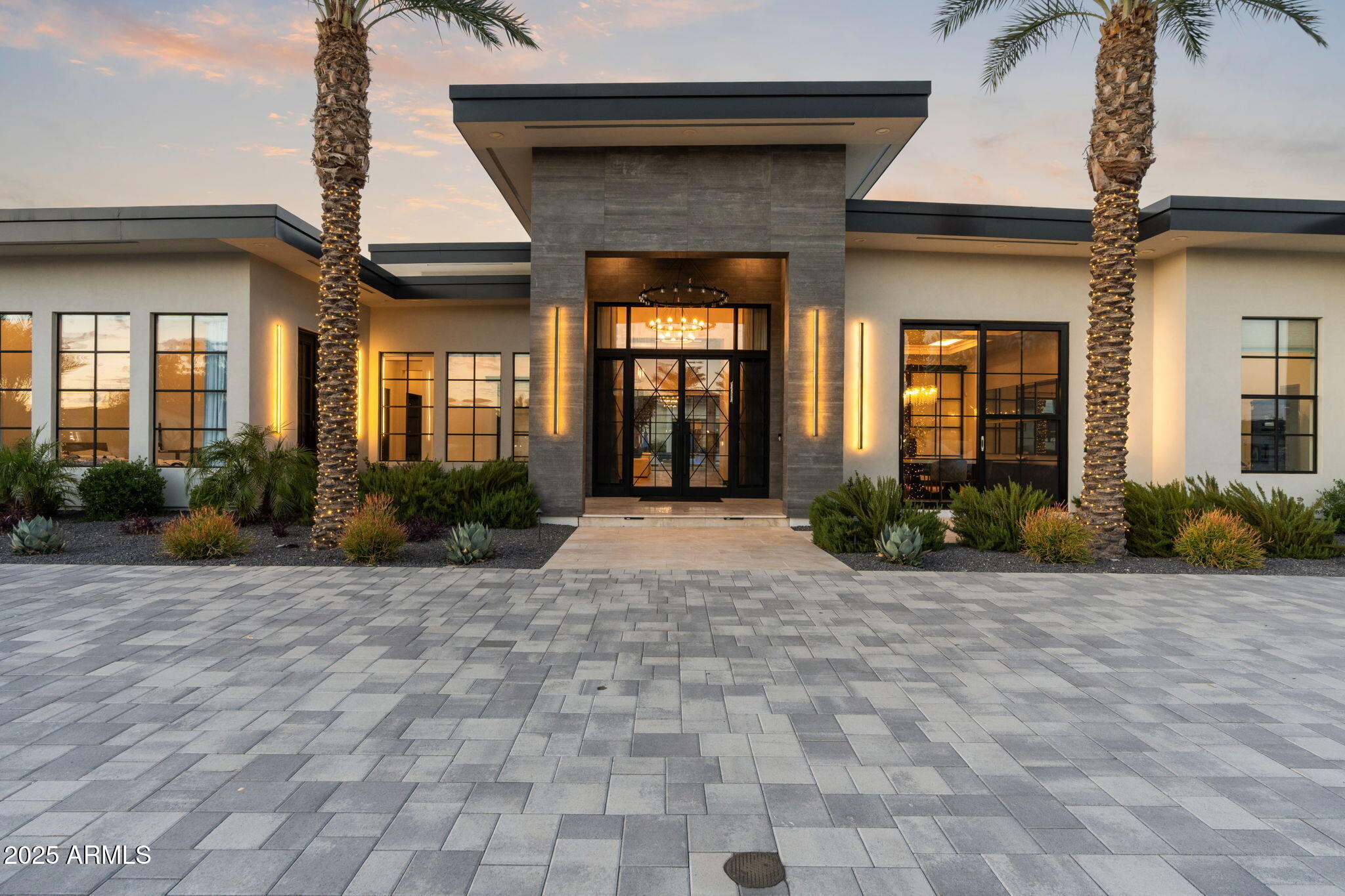 Discover unparalleled luxury in this 2022 custom built estate nestled in the heart of Paradise Valley, meticulously designed for family entertaining. The expansive kitchen is a culinary haven, boasting an oversized island, Sub Zero fridge and freezer, dual Cove dishwashers, never used Wolf steam oven, Transform home entertaining in the expansive game room. The bar is equipped with beverage fridges and an ice maker. The family room, adorned with 16' ceilings, seamlessly connects indoor and outdoor entertainment area spaces through an expansive 22- ft retractable pocket door flooding natural light framing breathtaking views. Indulge in casual dinners or elegant affairs in the formal dining room. Featuring 40 custom designed iron doors this residence showcases modern elegance in every detail The primary suite is a true retreat, centered around a fireplace encased in gold inlaid white marble tile and a resort style bath with a steam shower, soaking tub, beverage bar, separate laundry area, dual walk in closets. The kids' wing offers three additional ensuite bedrooms with walk-in closets off of a central flex/game room. Enjoy working from home in the office with custom ceiling details, French Doors to the side courtyard and a private half bath. Elevate your living experience with a Smart Home, controlled by a state-of-the-art Control 4 Home Automation System managing lighting, thermostats, cameras, security, and audio. The four-car garage boasts insulated doors and epoxy floors. Step into a resort-style backyard with expansive limestone pavered patios overlooking a custom basketball court and a stunning heated pool with baja step, cascading water features, fire features and spa. Relax by the gas fire pit poolside or temp your tastebuds at the 42" built-in grill with a never used pizza oven. Guests will feel right at home in the detached casita with one bedroom, 1.5 bath, gym room and a separate living room with kitchenette and laundry area. Captivating finishes include European Oak floors, synthetic stucco, exterior limestone accents, custom iron gates, stone, marble, and granite finishes, LED lights throughout, and wood-clad Low-E windows. Additional features include two gas tankless hot water heaters, upgraded foam insulation, a high-pressure misting system and much more in this extraordinary home!