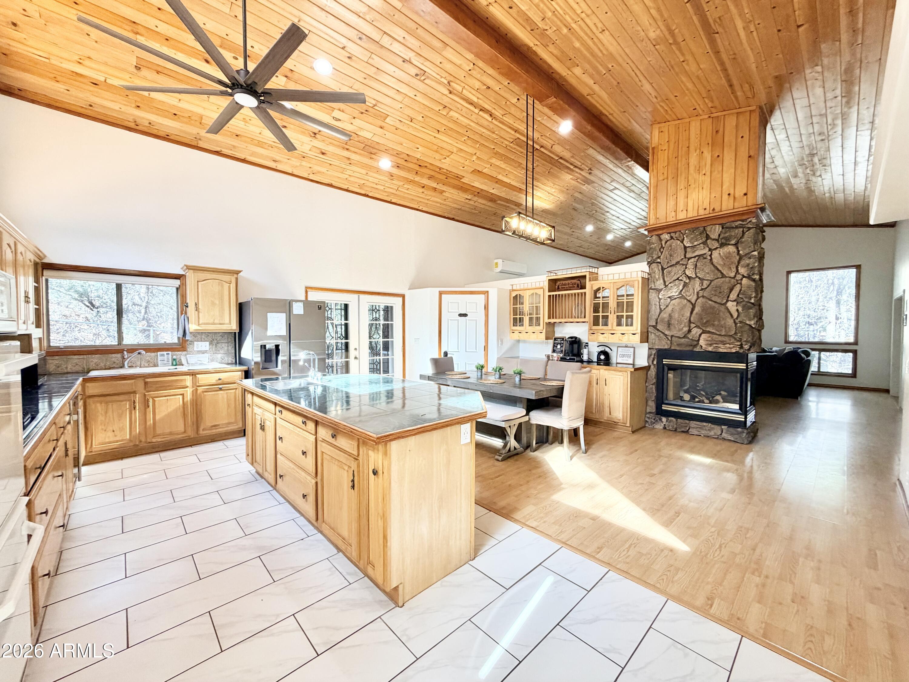 This beautiful home is set on nearly half an acre, with 4-large bedrooms & 2.5 bathrooms it offers generous space, character, and versatility both inside and out. From the moment you enter, the home feels open and inviting, enhanced by very tall ceilings that create a bright, airy atmosphere and add to the sense of scale throughout the living areas. Neutral finishes complement a flexible layout designed for comfortable living and easy entertaining. A standout feature is the custom bar and entertaining area with built-in cabinetry and sink, providing a unique gathering space that seamlessly connects the main living areas to the outdoors. Multiple exterior doors bring in natural light and offer convenient access to outdoor spaces.  A large workshop or storage space adds functionality.