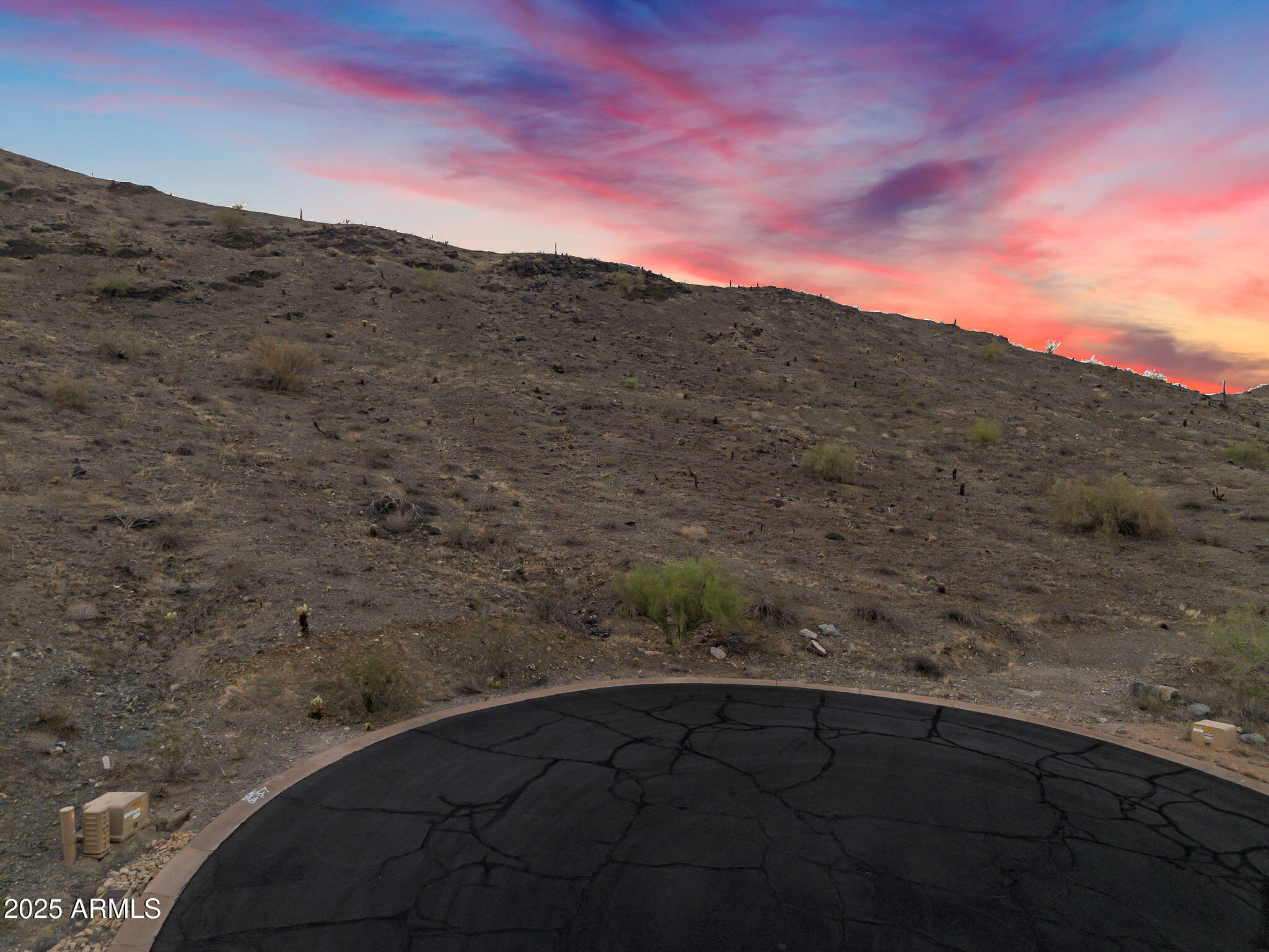 Rare 1.93-acre homesite in an exclusive gated enclave of the Ahwatukee Foothills. Perched for dramatic city light and mountain views, this premium lot offers a 12,000+ sq ft building envelope—perfect for a luxury desert retreat. Enjoy unmatched privacy, direct access to golf and hiking, and the top-rated Kyrene School District. Just 30 minutes to Sky Harbor and Scottsdale, this is desert living without compromise. Geotechnical report complete—bring your vision to life.