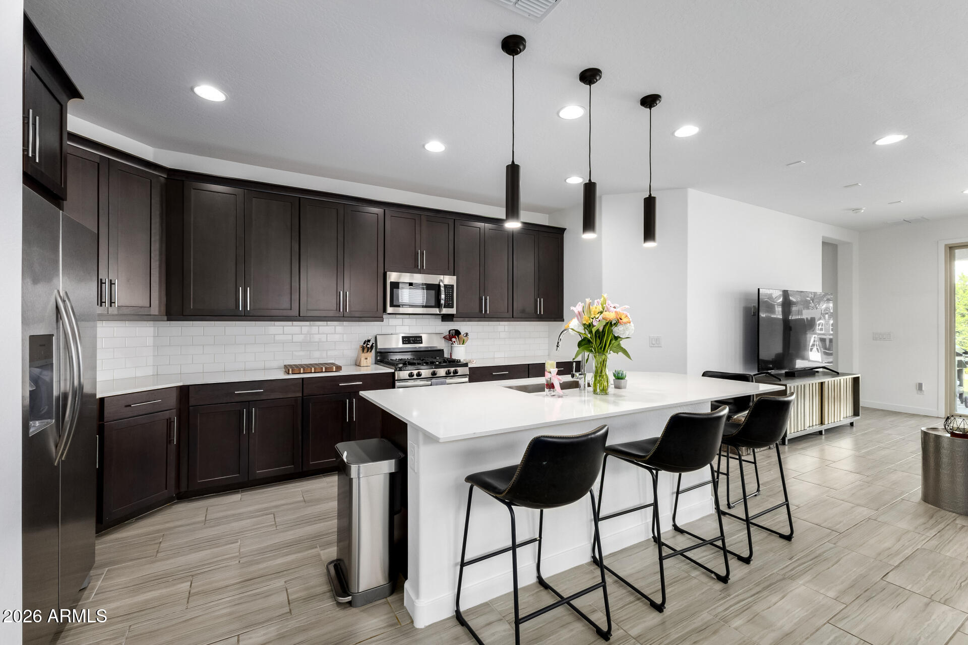Beautiful home in Northern Crossing in Waddell, located near Loop 303 and Northern Ave in one of the West Valley's fastest-growing areas. This single-story home offers 4 bedrooms, 2 bathrooms, and 1,925 sq ft of open-concept living with updated flooring throughout. The upgraded kitchen features Quartz countertops, pendant lighting, and generous prep space, flowing into the living and dining areas. The living room is prewired for surround sound, perfect for entertaining. The primary suite offers a spacious walk-in closet and upgraded walk-in shower. An upgraded double-door slider opens to the backyard with turf, lush landscaping, and mature privacy bushes, creating a peaceful low-maintenance retreat. Conveniently located near shopping, dining, & Westgate Entertainment District.