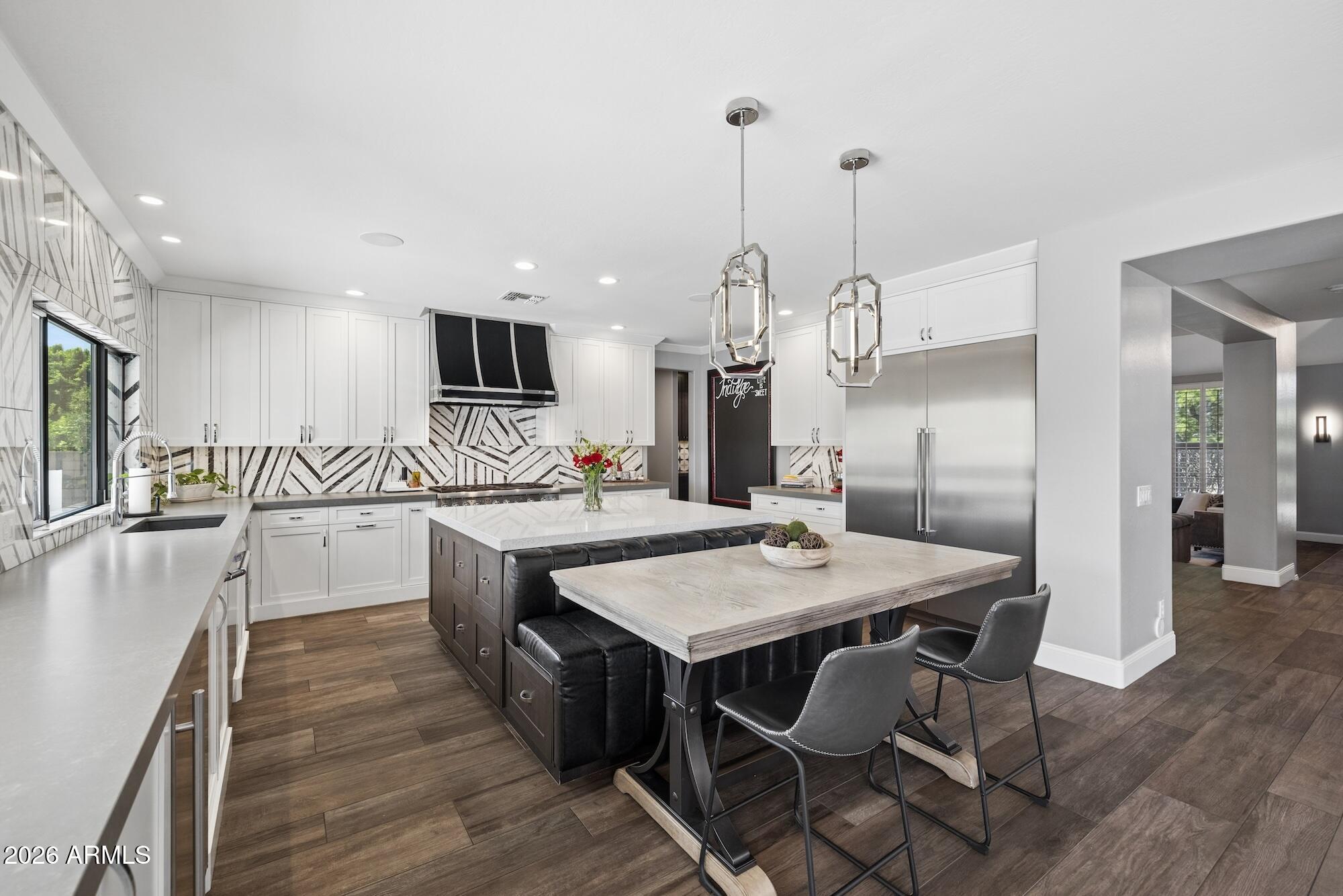 Exceptional entertainer's residence offering seamless indoor-outdoor living, thoughtfully designed and professionally curated. The chef's kitchen features custom Burdette cabinetry, a Thermador 6-burner gas range with griddle and dual ovens, and a striking artistic statement hood. Designed for effortless hosting with three dishwashers, filtered water at kitchen and bar sinks, expansive pantry space, and an updated bar with ice maker, wine, and beverage refrigeration. Designer lighting on dimmers creates a warm, sophisticated ambiance. Fully reimagined by an interior designer, the home blends elevated style with everyday livability. The resort-style backyard showcases an extended covered patio, built-in BBQ, custom fire feature, integrated surround sound, and a dedicated pool bath. The primary suite offers a spa-inspired retreat with a full steam room integrated into the shower.