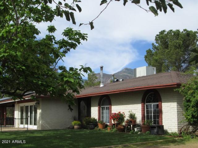 This is a MUST SEE 3 bd/2ba home! There are many fantastic amenities and unique qualities that you will enjoy. These include an outdoor fire ring, front and back patio areas for entertaining and an abundance of fruit trees. The interior of the home boasts built-in bookcases, A/C, a huge double pantry, double paned windows, a wood burning fireplace and amazing  artistry carved into the interior doors. There is plenty of room for extra vehicles or RV's on this 2+ acres that includes a 1+ car detached garage/workshop with full bathroom, RV hookup and a 2 car carport. This beautiful home is fully fenced and tucked in among huge pine trees with mountain views. Call for a private viewing today!