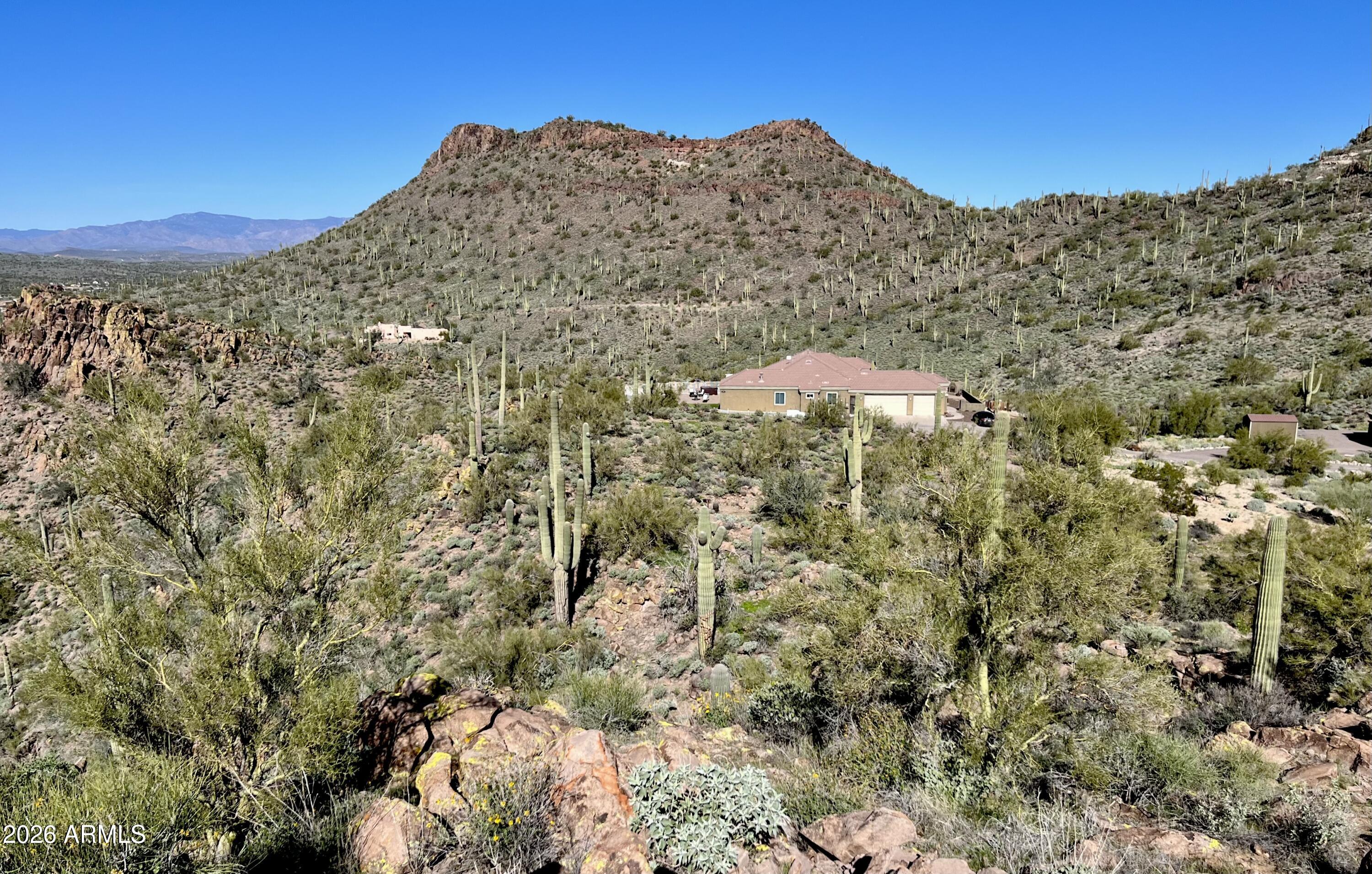 Great opportunity to own a sloping lot with 360 degree views from the top, including views looking west to the sunset from the peak. Or build lower on the lot and have 180 degree views to the East. Shared well is on the NE corner close to 10th St. With some minor excavation there are a couple semi level sites that would be nice for building. Or live like a King or Queen and build on the very top! This lot continues OVER the ridge to the west, and up to the landscaped portion of the home to the south. There is a vacant lot to the north before you see the nice home that's already built there.  New River is a sleepy suburb of Scottsdale and Phoenix sitting over 1000 feet above downtown Phx. The well is in with electric and supplying the house to the south already!