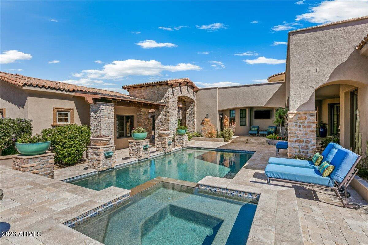 **Full Golf Membership Available with board approval.**
This tastefully remodeled Mediterranean-style courtyard home is a private, resort-inspired retreat, perfectly designed to maximize its exceptional lot location. Enter through massive wooden gates into a stunning front courtyard where a sparkling pool, spa, and tranquil water features create an unforgettable first 
impression. An automated pocket door seamlessly opens the great room and kitchen to the outdoors, blending indoor and outdoor living into one expansive, light-filled space. An
elevated courtyard patio captures breathtaking sunset views and features a dramatic fireplace and built-in barbecue island--ideal for entertaining. Inside, rich textures and custom details abound, including new wood flooring, exposed wood beams, a striking stone fireplace, and extensive built-in cabinetry throuout the home. The private guest casita is ideally situated across the pool, oriented toward the charming front courtyard. An exceptional value for a home of this caliber within a premier private golf club community.