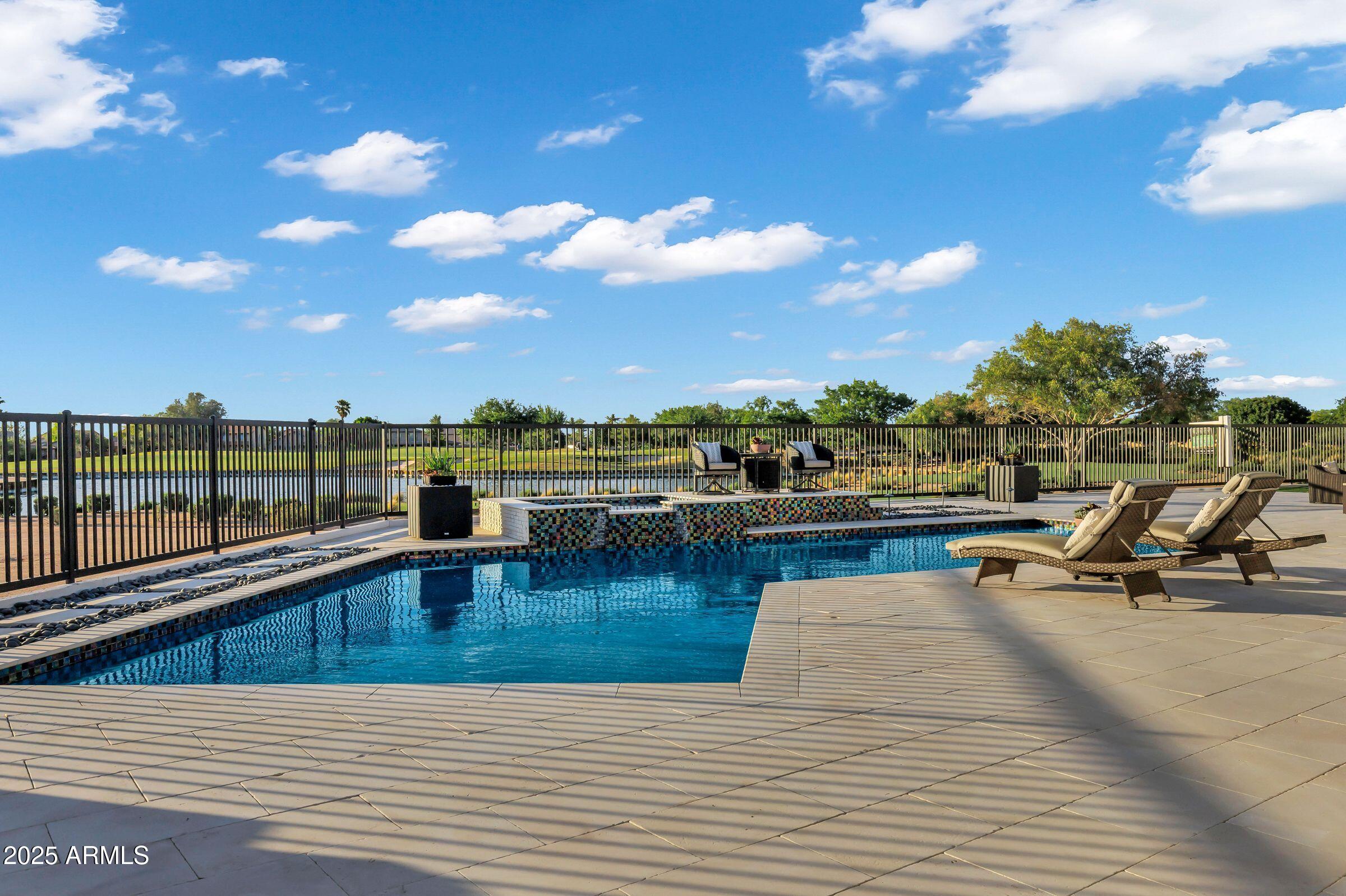 Welcome to your dream home nestled in the prestigious 'Legacy at Seville' community of Gilbert! This magnificent residence is not just a home; it's a lifestyle, offering unparalleled luxury situated on the Seville Golf and Country Club's signature 17th hole island green! With direct gated access to the country club, this home is a haven for golf enthusiasts and those who appreciate the finer things in life. Spanning an impressive 4,402 square feet on THE BEST LOT IN ALL OF SEVILLE, this exquisite property features a customized wide open floor plan with a luxurious primary suite, 2 en-suite rooms, a bonus/flex room and a lavish guest bath in the main house, with an additional rare gem - a 1,200+ sq ft detached guest house.... The guest house boasts 2 en-suite rooms, a full kitchen, open living room concept, full laundry room, its own oversized garage and private yard space! Constructed without compromise, the guest house offers endless possibilities for hosting guests or serving as a private retreat such a spacious home office, an in home gym, multi-generational living, live in help, rental space and so much more! 

The sprawling floor plan of the main house seamlessly blends indoor and outdoor living spaces, making it perfect for entertaining or simply enjoying quiet moments at home. The recently remodeled kitchen is a chef's dream with custom cabinetry, gorgeous Quartz counter tops & backsplash, under cabinet lighting, top of the line Thermador appliances and a HUGE island featuring a built-in ice maker, beverage center and custom charging stations. Soaring 12-foot ceilings, custom lighting, plantation shutters, decorative walls and ceilings throughout the home add to the sense of grandeur.

The luxurious primary suite is a sanctuary of relaxation with views of the backyard, remote shades, a large soaking tub, walk-in shower, dual vanities, custom mirrors and lighting and a custom walk-in closet. Every detail has been meticulously designed for comfort and style.

Step outside to the backyard oasis where you can unwind or entertain in style. The heated pool & spa are perfect for year-round enjoyment, while the firepit offers a cozy spot on cooler evenings. Panoramic views of the 16th, 17th & 18th holes provide an ever-changing backdrop of beauty and serenity. Sunsets here are truly incredible - easily making this one of the best lots in the entire community.

This unique home is a rare find and represents an exceptional opportunity to own a piece of paradise in one of Gilbert's most sought-after communities. Whether you're looking for luxury living at its finest or a versatile property that can accommodate many different needs in lavish comfort, this home checks all the boxes.

Discover your next chapter in this extraordinary residence where every day feels like a vacation. Your dream home awaits at 3842 East Alameda Lane!