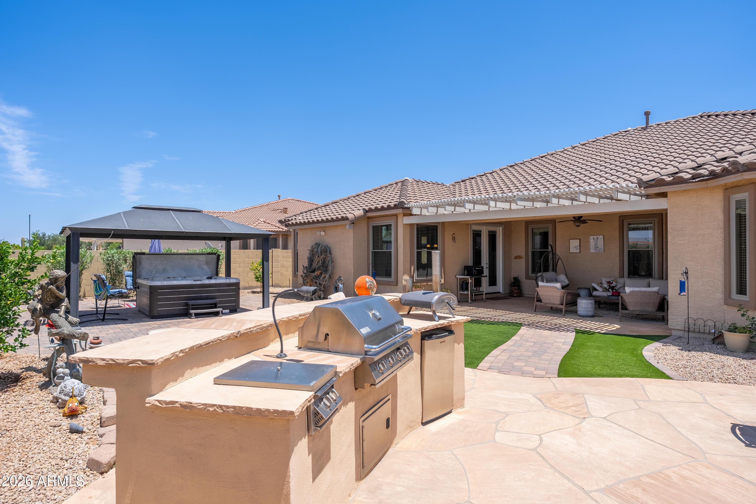 Rare opportunity to own a single-story home with over 3,100 sq ft in the highly desirable Palm Valley community of Goodyear. Situated on a 10,389 sq ft lot with no neighbors behind, this 4-bedroom, 3-bath home also features an enclosed den that can easily serve as a 5th bedroom, office, or flex space. Major upgrades include a new roof, paid-off solar, and new energy-efficient windows. The bright kitchen offers granite countertops, abundant cabinetry, and plenty of natural light. Hardwood and tile flooring run throughout much of the home. Enjoy Arizona living in the entertainer's backyard featuring turf, a fire pit, covered patio, and jacuzzi. Complete with a 3-car garage, built-in storage, and close proximity to parks, walking paths, schools, and the Goodyear Recreation Center. COME SEE!