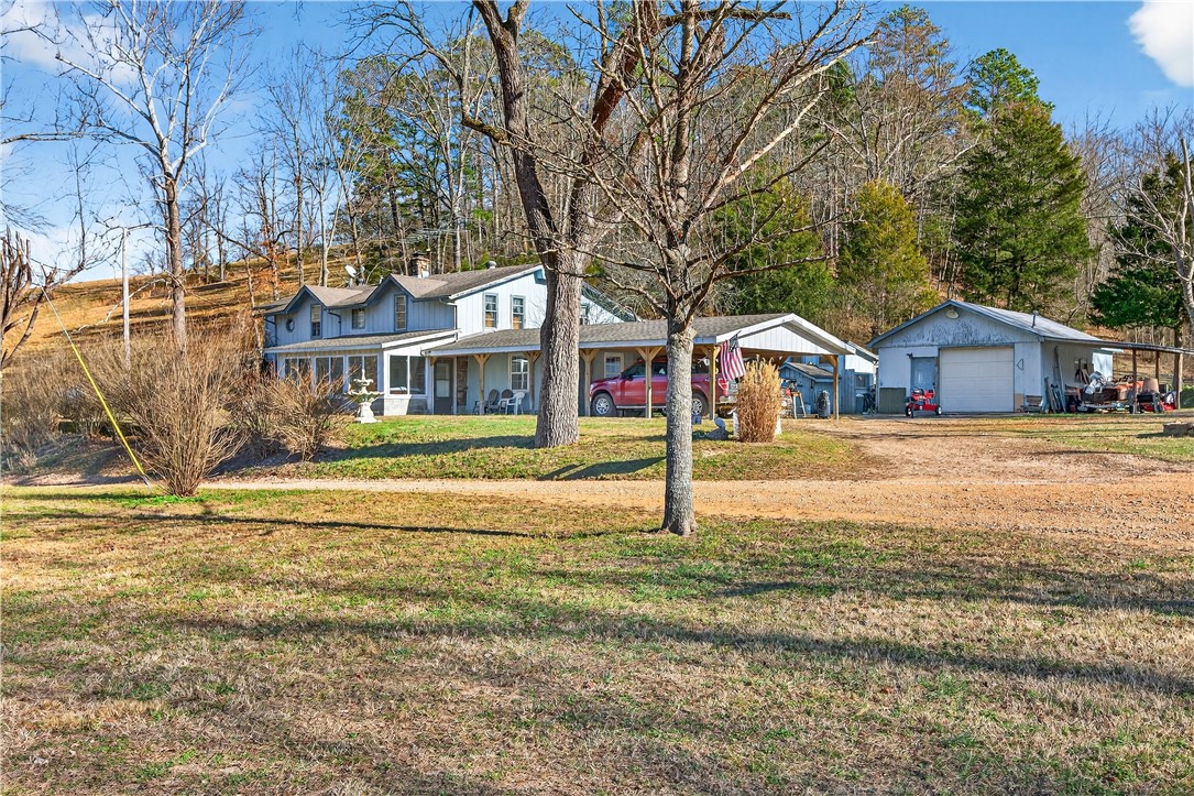 Country living on 2.25 acres with nice 4 bed 4 bath two level home. Native stone fireplace, Built in Concrete Storm Shelter. Work shop, green house and water well for all your gardening needs. Two nice sized storage building with Electric and Water. Boat launch 3 blocks from the house. Come add your updates and make this property your home.