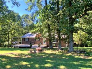 Rare opportunity to own 11 level acres with a pond and a updated brick home, not far from town! The home features 3 bedrooms and two full baths on the main level, plus large living room w/ gas fireplace, and spacious eat in kitchen w/newer appliances and concrete counter tops. The walk out basement has large den area, office area, full bath.  Many updates in the past few years including HVAC, Flooring, appliances, countertops, bathrooms,windows and metal roof. The home is at the end of the lane for privacy and has a large deck, perfect for viewing wildlife. The home is on rural water, but there is a well, owner has never used it.