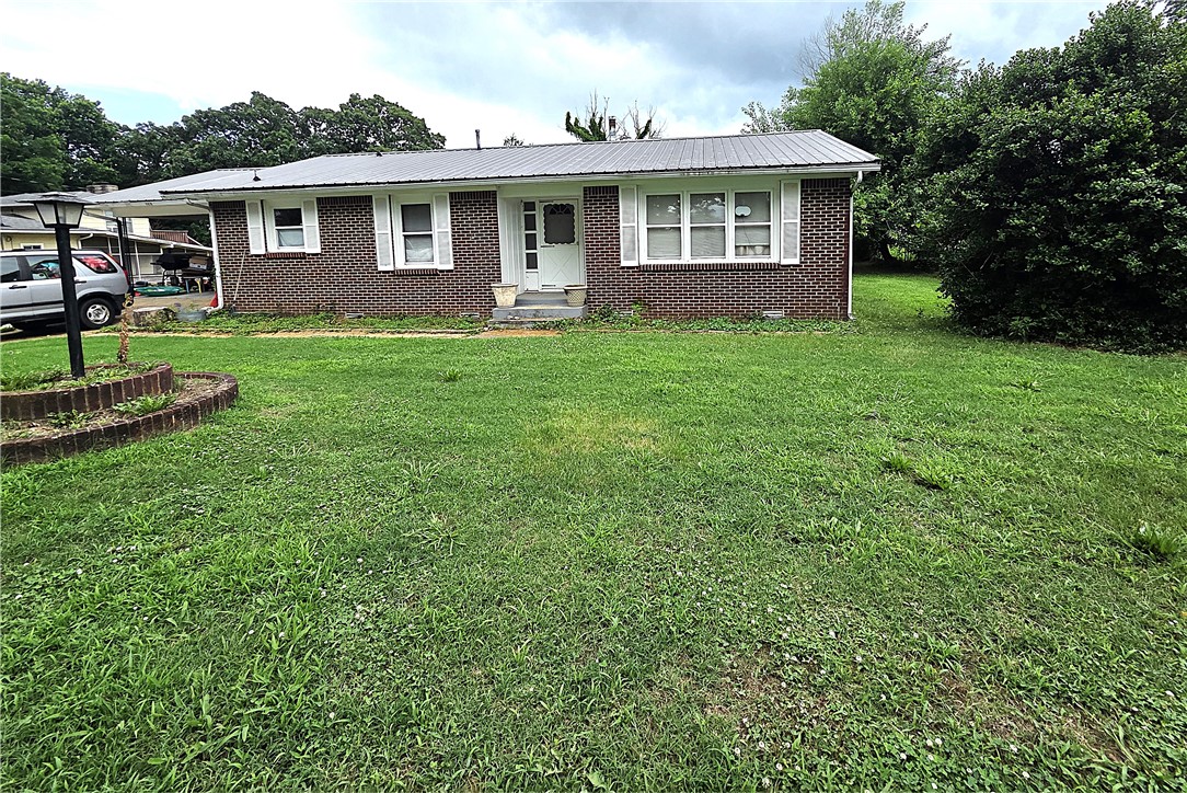 You will love this brick 3 bedroom home that was remodeled in 2024, solid and clean, move in ready with beautiful wood floors, metal roof and approx. 1/2 acre lot. Very nice neighborhood not far from hospital and school.