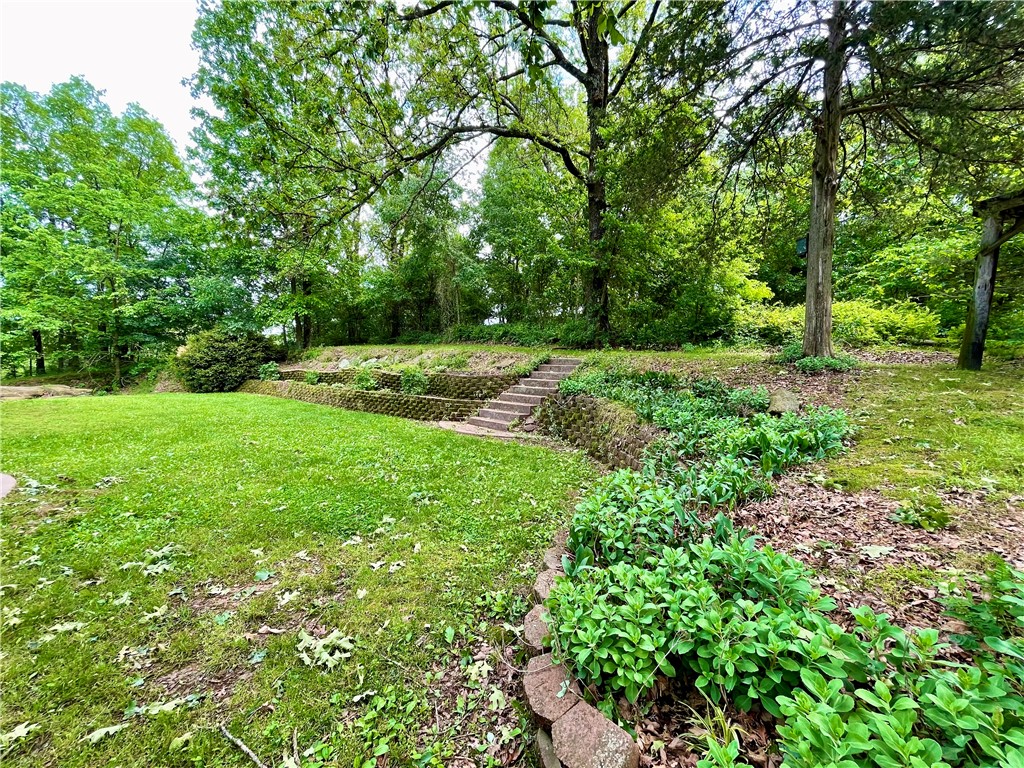 Easy commute, rare opportunity, come see this property!! **Sellers to provide a $5,000 seller concession at closing**Beautiful park like setting on 2 acres m/l sprinkled with mature trees surrounding a prime multigenerational opportunity just under 5 miles from Huntsville! This expansive home boasts 7 beds/4.5 baths total, 4/4 upstairs, featuring a great layout with elevated front-yard views. 20X30 metal storage building. The real bonus is the versatile lower level with its own private garage access, approx 1462 sq ft great for a dual-living suite, mortgage helper, or income-generating rental. Discover endless possibilities for income and flexible use—come see it today! 
Great location off of hwy 74 for easy commuting all over NWA!!!