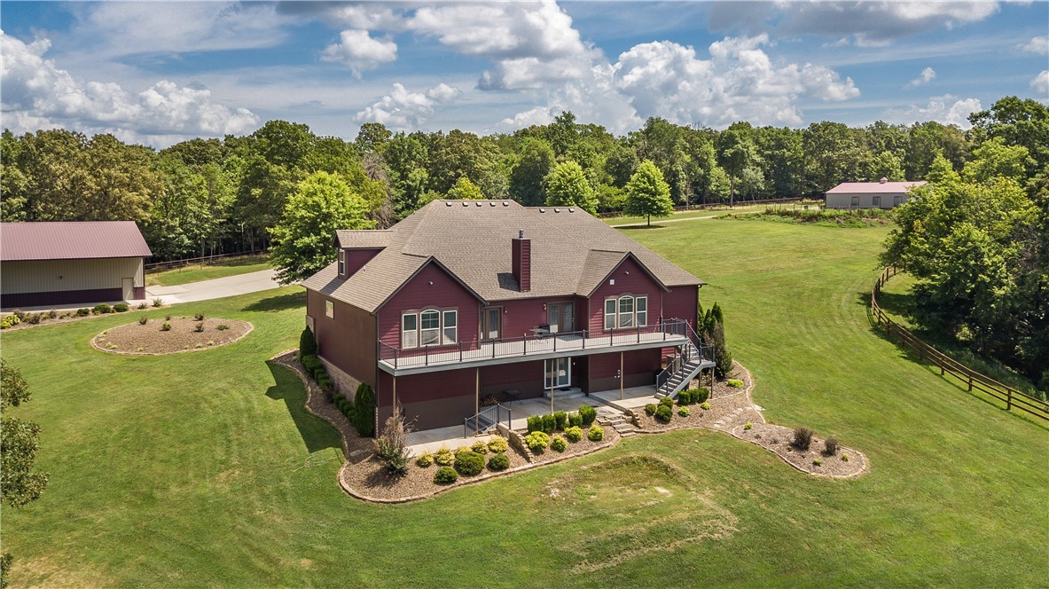 Welcome to this stunning estate offering unparalleled features & functionality across multiple levels & structures. Spanning 10 acres of beautiful grounds, this property is a true haven for those seeking space, comfort, & amenities. The main house boasts a stunning living room w/vaulted wood ceiling, fireplace, double doors out to a 60ft deck, crown molding, and built-ins. The office is ideal for remote work or a private study. The dining room is perfect for formal gatherings or intimate meals. A gourmet kitchen comes fully equipped w/ recessed lighting, soft-close cabinets, granite countertops & instant hot water. The lower level entertainment area includes a built-in bar & a locking gun room & opens to a covered patio for outdoor enjoyment. The  1bd/1ba guest house offers comfort & privacy w/ hardwood flooring, crown molding, and a covered deck for relaxation. The 40x50 shop has 30 &50 amp service. The 6 stall horse stable w/ tack room is equipped w/water & a propane heater plus a horse washing station.