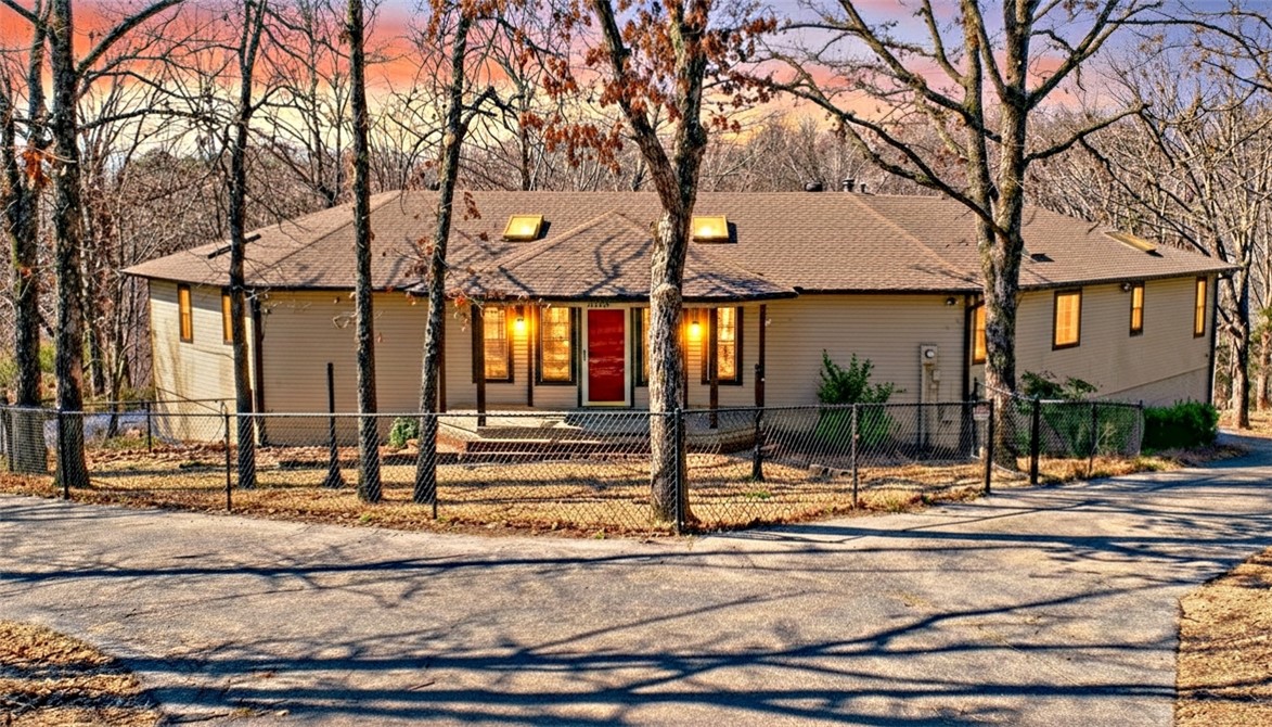 Private setting on 2.22 ac. Minutes to Beaver Lake, Short drive to downtown Rogers, Huge deck for morning coffee & entertaining. Plenty of room for pets to play. Well-built home: 2x6 framed walls for better insulation, poured concrete basement walls, & Anderson windows! F/P mantle from Monte Ne Hotel. Main level is a split plan boasting a guest bedroom w/ private bath & a huge primary bedroom with a large room just off primary for office/workout space. large walk-in closet & primary bathroom that has large tub and separate shower. Lower level offers walk out patio, open game room with wet bar/kitchenette, 3rd bedroom, full bath. Basement has two different garages that heated/cooled. One oversized 1-car & other garage is an oversized 2-car w/ shop area & work room. Garages have 18x8 overhead doors dimensions 2020 upgrades include new paint & carpet throughout & new upstairs HVAC system. New Roof. Gated driveway for security & paved drive around the entire home for plenty of parking & RV septic connection/ cleanout.