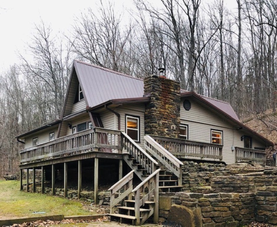 Overlooking Greasy Creek Valley, this 1240 sq. ft. home and 17 plus acres enjoys intriguing out door living areas enhanced by natural rock outcroppings. Perfectly cared for, the centrally heated 2 bedroom 1 bath home has native stone fireplace with insert and handsome warmly finished alder wood kitchen cabinets. 400 sq. ft. screened back porch has its own private woodland window. Creekside in the valley, a 2nd water tap services a farm pump and the 720 sq. ft. workshop with electric. Also the historic Old Durham Canning Factory (48x48 moved to and operated at this site in the 1930's) is currently used for storage and RV parking. The sights and sounds of Greasy Creek are an inspiration at the hillside home and in the valley.