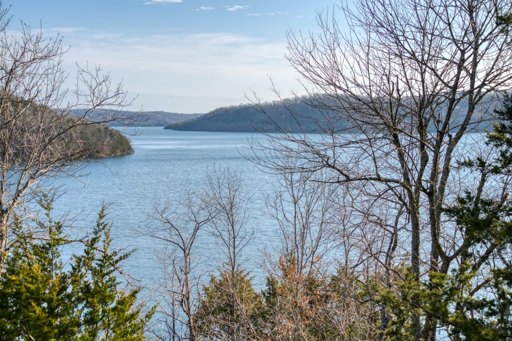 18.9 acres of possibilities, exploration, and lifelong fun! Large pieces of dock zoned Beaver Lake front land are EXTREMELY hard to find and this one includes a private dock! This land is located in an area of high-end homes, is easy to get to on paved roads, and offers the privacy that you’re looking for. The main ridge is broad and flat and could be cleared for some amazing views of the main channel! Large cliffs, boulders, wet weather creeks, waterfalls, and springs make this an amazing piece to hike and explore! This land has approximately 1100 feet of dock-zoned lake frontage with a point on the Corps-line that is currently in the water! Existing dock has been relocated to this location so you will be able to drive an atv/utv right to the dock walkway! Area immediately above dock location would be an excellent spot for a firepit, hang-out deck, or a “boat house” near the water. Existing trails around the property including one that quickly takes you from the top of ridge to the dock location.