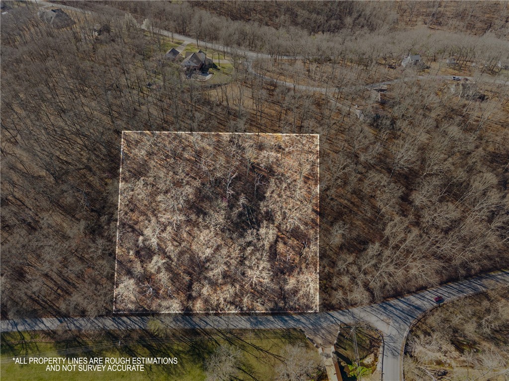 Location, Location, Location - BEST OF BOTH WORLDS - In the county, outside of city limits with lush trees, hills, and starry nights! Only 5 minutes from I-49, 11 minutes from Downtown Bentonville and 14 minutes from Walmart HQ. Less than 2 miles from the new OZ Trails system park with a gondola that is planned just west of 71Business. Discover +/- 4.91 acres of wooded land for sale just outside of Bentonville, offering the perfect opportunity to build your dream home in a peaceful yet convenient location. Situated near E McNelly Rd, this property is approx. 1.5 miles from US 71 Highway and just 2 miles from I-49, ensuring easy access to nearby amenities, shopping, and dining. Located within the highly sought-after Bentonville School District, this land provides an excellent investment in a rapidly growing area. Don't miss out on this prime piece of land in a thriving Northwest Arkansas Community! Seller is willing to split up the lots in different sizes so long as the county will approve.