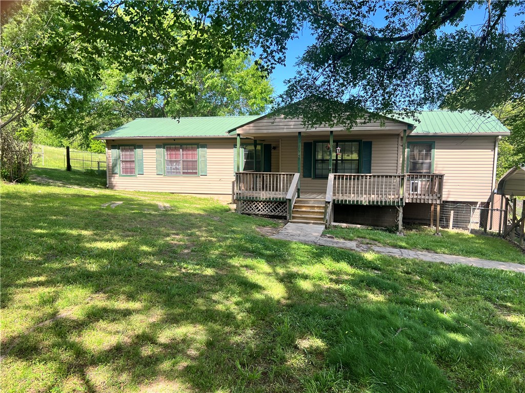 Your hobby farm awaits. Property includes 5 acres mostly fenced and cross fenced, out buildings include 30 x 40 hay barn, 24 x 36 garage with opener, 2-18' x 20' carports. RV space with electric and own septic. Pull up to automatic gate that opens up to wonder property, this home offers 2 bedroom, 2 baths, office, open kitchen, living room and a dining area, semi finished basement, washer, dryer and freezer all convey, Home needs to be finished out so bring your vision, imagination and DYI self and finish out to your personal taste. Enjoy the view and great outdoors on your large back decks with above ground swimming pool, the fenced back yard is separated. The large covered front porch is a perfect place to sit back and relax, enjoy the park like treed fenced front yard. Entry gate and upper property entry gates are remote or touch pad controlled, security cameras convey. This property is a must see, pasture grass is ready for your farm animals and ready for you to enjoy your new home.