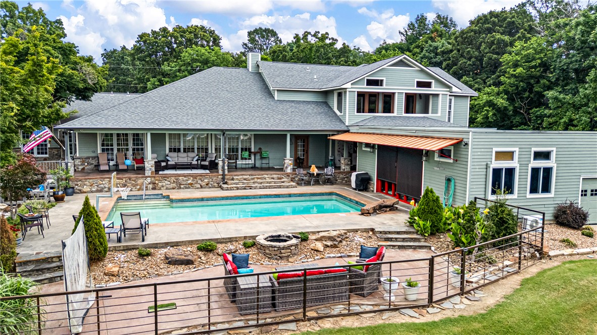 Rare Opportunity to own Seclusion with a VIEW! This location, off of Skyline Drive, is prime for the active family that enjoys entertaining, wide open space to explore and wants to be close to the state parks for trails. The view to the South of the Arkansas River and Mt. Nebo can be seen from the patio, Master Suite Balcony, and from inside the home. Professional Landscaping on the exterior with a Professional Kitchen on the interior continue bring the entertaining inside. This home boasts living spaces connected with a living room w/fireplace, along with an impressive Master Suite upstairs. The Pool House is heated and cooled with a kitchen and lounge space to enjoy. Store your boat, four wheeler or other toys in the 1000sf detached shop or in the shop attached to the pool house. Geothermal system provides for efficient, eco-friendly comfort. Look no further for the perfect place to relax, entertain, be close to parks and to all that Russellville has to offer.