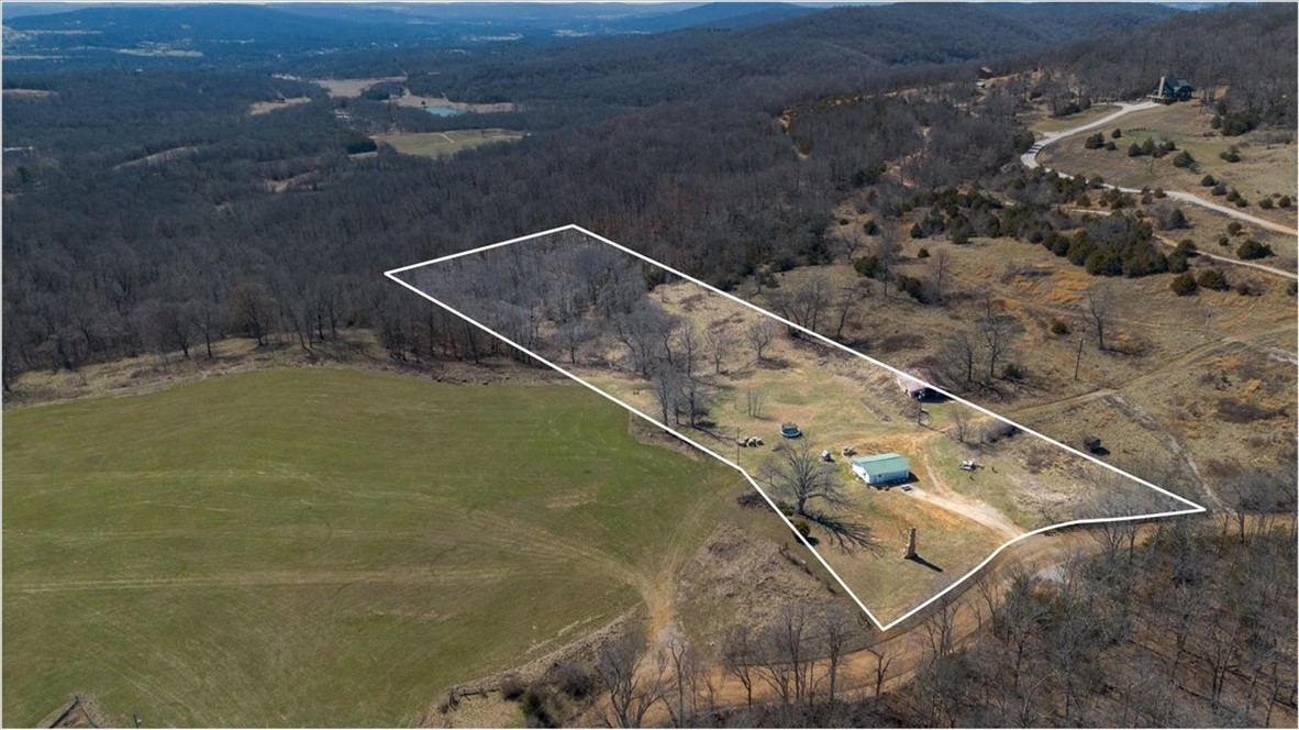An incredible opportunity to own 4.31 acres in the heart of South Fayetteville, offering the perfect balance of privacy, convenience, & breathtaking views. This prime location with new construction homes being built in the neighborhood, is just minutes from the University of Arkansas, downtown Fayetteville, & HWY 49. Plus, it's only a 1/4 mile walk to the Kessler Mountain trailhead, providing access to Kessler Mountain Regional Park & the South trailhead of the Razorback Greenway trail system. With stunning panoramic views of the Boston Mountains, this property is an ideal setting for your dream home. Located just outside the Fayetteville city limits, you'll enjoy peaceful country surroundings, abundant wildlife, & a sense of seclusion while remaining close to all that NWA has to offer. The cozy living quarters feature an open floor plan, kitchenette, bathroom, shower, vanity & commode, making it a perfect place to live or stay while building your dream home. Property is being sold "As Is" & value is in the land.