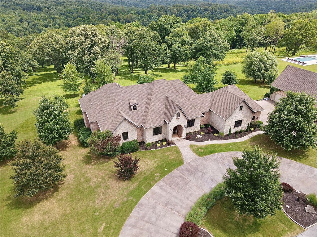 This stunning luxury estate in coveted gated community is the stuff dreams are made of. Park like setting on 7 professionally landscaped acres with vista views. Almost 6000 sq ft. of custom designed high end features in every room. Dramatic entry, gorgeous hard wood floors, 12 ft coffered ceilings, chandeliers, massive windows and high end crown molding. Energy saving features throughout including geothermal H&A. Grand chef's kitchen with Carrera marble top island, soap stone countertops, huge butler's pantry, floor to ceiling custom cabinetry, formal dining. Spacious master suite with spa like bath and incredible walk in closets.Newly tiled second floor 2000 sq ft of deck space for entertaining around a 40x18 Mediterranean style pool. 119" projection screen in media room/2nd living room with surround sound. Tons of storage 
Quiet, serene, quality living within walking distance of Sassafras Winery & White River. Only 5-10 minutes from Fayetteville Mall, shopping, restaurants and schools.