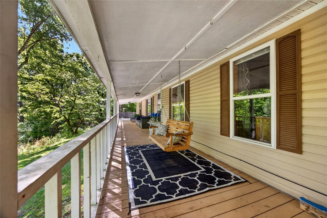 Peaceful country living with room to breathe. Situated on nearly 19 wooded acres, this property offers the privacy and quiet so many buyers are searching for while still being conveniently located just minutes from Hwy 412. The wraparound porch is truly the heart of the home, it's the perfect place to enjoy your morning coffee, unwind at the end of the day, and take in the sights and sounds of nature, and other wildlife frequently passing through the property. Around the home, you’ll find several great flat, usable areas ideal for gatherings, campfires, outdoor activities, gardening, or simply enjoying the space and freedom that comes with country living. Sellers have spent considerable time cleaning up and improving the land around the home and will also leave a generous supply of firewood ready to use. The property includes a detached 24x30 two-car shop, along with an additional storage shed added by the current owners that will also convey.