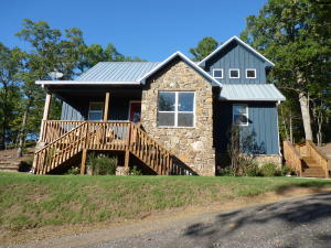 1952 sq ft home that is about 2 yrs old with granite kitchen and master bath, wood flooring, cathedral ceiling, in ground pool, 3 minutes to boat launch, and privacy. This 3 bedroom 2.5 bath home has a covered patio and balcony porch and poolside pergola, half bath and shower. The fireplace and retaining wall are stacked rock. Steps and pool area are rocked as well. 2 car detached carport has a storage room plus floored attic storage. Bluff lake front above the house would make a nice place for a gazebo.