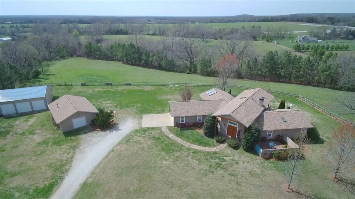 Wonderful home on 10 acres of very good pasture, perfect for horses or cattle. An additional 5 acres available. Spacious open floor plan with soaring ceiling and fireplace. Several recent updates including HVAC and refinished hardwood floors. Lovely outdoor entertaining spaces with mature landscaping. Great shop for all of your hobbies and an additional three bay shop to-store your toys! Come see this fantastic home today. Only 15 min to Rogers, 20 to Bentonville