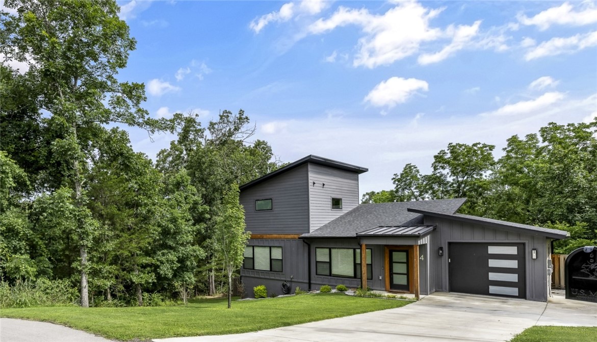 Adjoining wooded .31 acre lot is available for sale if purchased with this house; located in quiet culdesac with lots of trees which provides a nice natural setting. The modern architectural design of the house filled with lots of natural light along with white quartz counters & white cabinets in contrast with black trim & black accents is striking & aesthetically appealing; a good sense of design, color, symmetry. The primary bedroom & bath are upstairs with a double door that leads to a private deck. The primary bath has soaking tub, double vanities & walk-in shower. The 2nd bedroom & full bath on main level.  No carpet; all flooring is luxury vinyl plank & ceramic tile.  Kitchen has lots of cabinets, wonderful island & large walk-in pantry. Main level opens to spacious deck which faces the large back yard enclosed by privacy fence. Located close to Trails, Loch Lomond, Scottsdale Golf Course. The custom-built 10x12 storage building has electricity powered by solar panel.  Can convey: Refrigerator, Washer, Dryer.