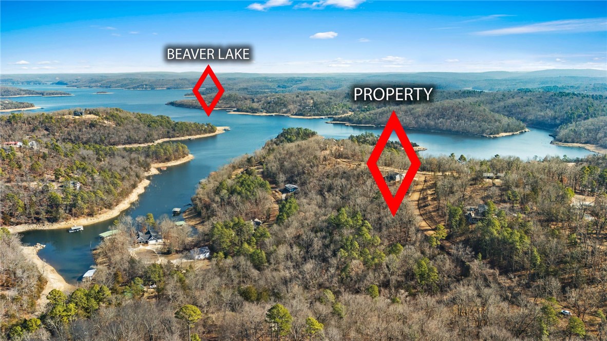 Two contiguous lots totaling 2.88 acres (1.11 & 1.77 acres) in the desirable Beaver Lake area. Enjoy a peaceful setting with a seasonal view of Beaver Lake and approximately 500 feet of road frontage. Located just 2.8 miles from Rocky Branch Marina and approximately 15 minutes from Downtown Rogers, offering the perfect balance of privacy and convenience. Public water and electric available at the street (water extension required). Septic system needed. Gently wooded with great potential for a private homesite or future investment.