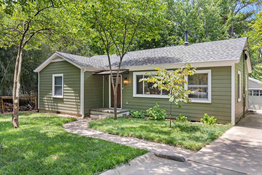Tucked along a quiet street in Fayetteville’s Historic District, this beautifully and extensively renovated 3-bedroom bungalow pairs timeless character with modern peace of mind. Surrounded by lush greenery, the home feels like a private boutique retreat inside and out. Original hardwood floors complement the custom white oak cabinetry, calming blue tile, abundant natural light and a cozy Lopi wood stove.  Extensive updates in 2024 include new roof, siding, HVAC, ductwork, plumbing, electrical, water heater, insulation, kitchen and bath—all permitted and inspected. New appliances convey. Enjoy morning coffee or evening drinks on the new back deck, while the detached garage offers flexible space for bikes, a home gym, workshop or hobby studio, complete with 240-volt power. The long driveway and additional parking add everyday convenience.  Located just blocks from trails, schools and shopping in one of Fayetteville’s most walkable neighborhoods.  Showings begin Tuesday, July 28.