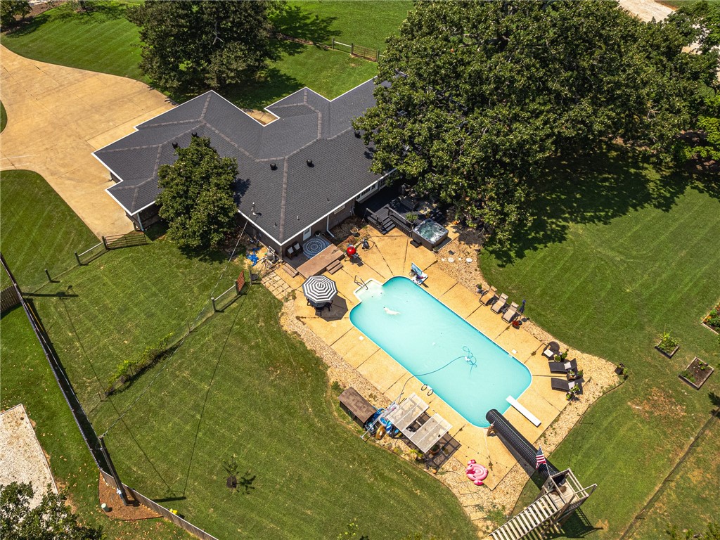 Prime Location: Bentonville Schools, Bentonville West HS, just 2 miles from I-49 and 8 miles from Downtown Bentonville! Welcome to this stunning 2,209 sq.ft. home boasting a bright, open floor plan with 3 bedrooms and 2 baths. Features include elegant built-ins, durable Pergo flooring, and brick/vinyl shake siding. Full 3-car garage with safe room/tornado shelter inside. Cozy wood-burning fireplace with steel liner & blower. Ample storage throughout. Large swimming pool, one-of-a-kind slide, and hot tub for relaxation. Beautiful 1.02-acre lot with mature shade trees, gardening beds, fruit trees, covered porches, and decks for outdoor living. Fully fenced yard with well house (public water option available; owner enjoys abundant, high-quality well water). Unique Opportunity: Previously a highly successful Airbnb, consistently fully booked! Ideal for families or investors seeking versatility. Seller offers $10,000 concession toward buyer’s closing costs. Don’t miss this move-in-ready gem blending comfort and charm.