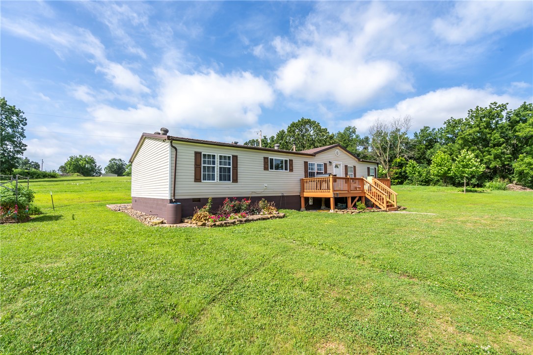 This inviting manufactured home is a comfortable 1740 square feet, offers a seamless transition into a lifestyle of comfort and convenience, ready for you to move in. The heart of this home resides in its thoughtfully designed kitchen, featuring a central island, tons of counter space, and a pantry. Living room space has enough room for the whole family as they gather around a cozy wood stove. Central HVAC, but also the wood stove and wall units will keep you cozy all winter.  With three comfortable bedrooms and a dedicated laundry room, this property is designed for practical living.  The 5.5ac gives you plenty of room for living a homesteaders dream. Additional access to public sewer and water allows space for added housing if you are looking for multi-generational living and building sites. Huge workshop provides opportunities for business, hobbies, additional storage, etc. Shop has electric, but also plumbing options.  There is also a spring fed creek along the northern edge of the property. Call today!