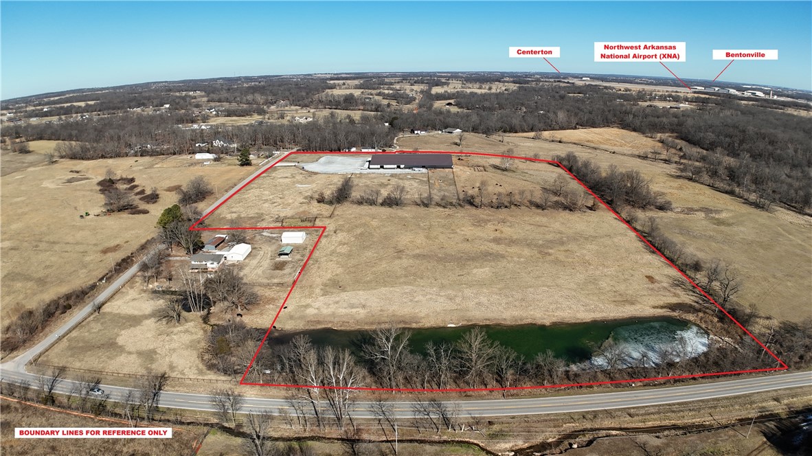 Exceptional 50,000 sq. ft. commercial facility on 25 acres just west of XNA Airport. This versatile property features full climate control, LED lighting throughout, and multiple oversized door access points ideal for industrial, storage, or logistics operations. Equipped with a commercial-grade septic system and private water supply, the building also includes comfortable living quarters for on-site management or staff. The expansive land offers a mix of open pasture and a large scenic pond—perfect for future expansion, outdoor storage, or recreational use. Prime location with easy access to major highways and airport logistics routes. A rare opportunity combining functionality, acreage, and proximity to Northwest Arkansas’ growing commercial hub. Designed for easy large vehicle access.
