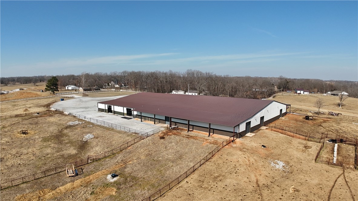 Exceptional 50,000 sq. ft. commercial facility on 25 acres just west of XNA Airport. This versatile property features full climate control, LED lighting throughout, and multiple oversized door access points ideal for industrial, storage, or logistics operations. Equipped with a commercial-grade septic system and private water supply, the building also includes comfortable living quarters for on-site management or staff. The expansive land offers a mix of open pasture and a large scenic pond—perfect for future expansion, outdoor storage, or recreational use. Prime location with easy access to major highways and airport logistics routes. A rare opportunity combining functionality, acreage, and proximity to Northwest Arkansas’ growing commercial hub. Designed for easy large vehicle access.