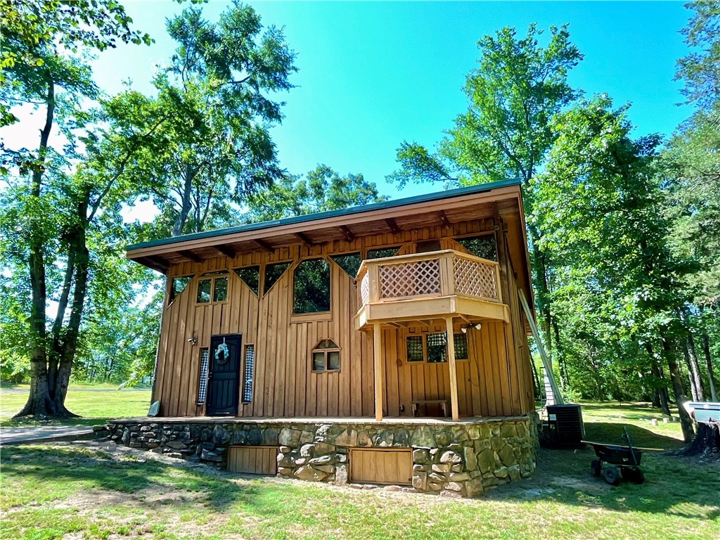 Unique Designed Wood sided home on almost 3 acres in the city limits of Clarksville this three bedroom, two full bath home offers, vaulted ceilings, unique floor plan, cozy kitchen, and lots of living space. The property is conveniently located next to modern conveniences and also Clarksville‘s country club and golf course just down the street. enjoy sitting on your front porch or the quaint upper deck. this beautiful property is priced to sell and offers so much privacy. 2 Car Carport too. All on a paved quiet street Minutes from I-40.