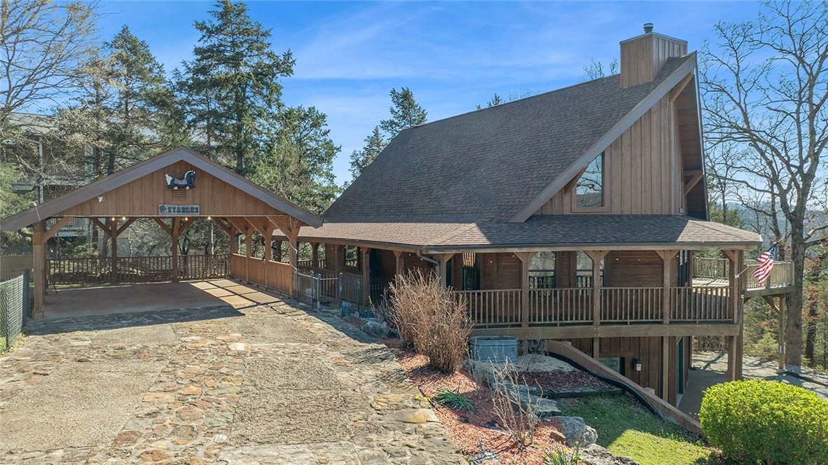 Welcome to your dream retreat in the heart of Holiday Island! This beautifully crafted three-story cabin offers the perfect blend of rustic charm & modern comfort! The open-concept living area showcases soaring ceilings, rich wood finishes, & large windows that flood the home w/natural light. The kitchen is designed for both functionality & style, offering ample counter space & cabinetry. Cozy up by the fireplace or step out onto the wrap around deck to relax & take in the peaceful surroundings. The master en-suite offers a huge walk in shower, soaker tub, & walk-in closet along w/acess to the back deck. The upstairs bedroom also includes a full bath. Downstairs could be used for additional sleeping quarters, hobby space, or game room. A Generac 24KW whole home generator was installed in 2024, new HVAC installed in 2025, & a new stove in 2025. Whether you’re enjoying your morning coffee, overlooking the lake or unwinding after a day on the golf course, this property delivers a true Ozark lifestyle experience.