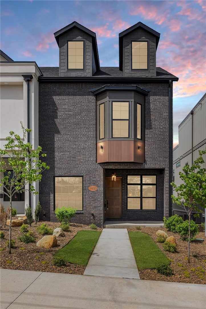 Brownstone character meets downtown Bentonville living. Urbane Oasis offers architectural depth, natural surroundings, a walkable lifestyle - coffee, restaurants, trails, & the square all within reach, without sacrificing privacy or finish level.
The main level flows from open kitchen with oversized island & walk-in pantry to a dedicated 1st-floor office built for remote work. The 2nd floor holds the primary suite with private deck, freestanding tub, walk-in shower, 2 add'l beds, full bath, & laundry. The 3rd floor opens to a large porch overlooking Park Springs Park - a natural view rare this close to downtown.
Site-finished wood floors, tall ceilings, quartz countertops, pre-wired sound & security, oversized 2-car garage, & an optional 4th bedroom on the 3rd floor.  ** Currently a 3 bedroom, bonus room shows modified plan with 4th bedroom option.
POA covers lawn care, window washing, & holiday lighting. Lock up and go. One of four bespoke homes in the Crystal Springs development on a .20-acre downtown lot.