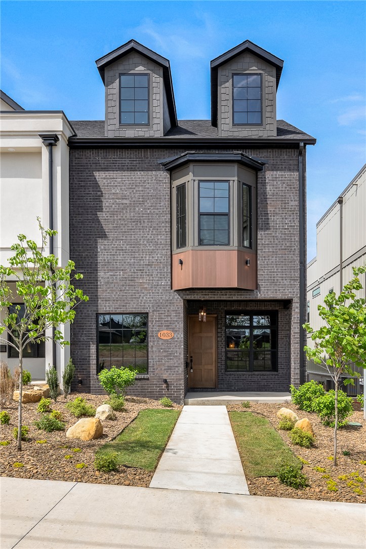 Brownstone character meets downtown Bentonville living. Urbane Oasis offers architectural depth, natural surroundings, a walkable lifestyle - coffee, restaurants, trails, & the square all within reach, without sacrificing privacy or finish level.
The main level flows from open kitchen with oversized island & walk-in pantry to a dedicated 1st-floor office built for remote work. The 2nd floor holds the primary suite with private deck, freestanding tub, walk-in shower, 2 add'l beds, full bath, & laundry. The 3rd floor opens to a large porch overlooking Park Springs Park - a natural view rare this close to downtown.
Site-finished wood floors, tall ceilings, quartz countertops, pre-wired sound & security, oversized 2-car garage, & an optional 4th bedroom on the 3rd floor.  ** Currently a 3 bedroom, bonus room shows modified plan with 4th bedroom option.
POA covers lawn care, window washing, & holiday lighting. Lock up and go. One of four bespoke homes in the Crystal Springs development on a .20-acre downtown lot.