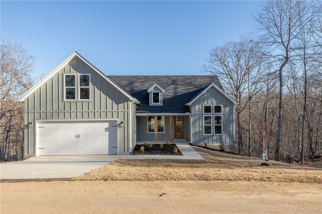 Designed with everyday living in mind, the home features a spacious split floor plan, cathedral ceilings, and white oak wood floors. The eat-in kitchen is equipped with quartz countertops, gas range, walk-in pantry, large island, beverage nook and mudroom drop zone just off the kitchen/garage entry.  The spacious primary suite offers a large walk-in closet and a spa-like bathroom with high-end features such as split vanities with smart LED mirrors, a soaking tub and glass enclosed tile shower.  The versatile bonus room above the garage—perfect for a theater room, home office, workout space, playroom or whatever creativity you want to bring.  Step outside to a covered deck overlooking the mature trees—an ideal setting for quiet mornings or relaxing evenings surrounded by nature. Located near parks, world-class mountain biking and walking trails, this home offers the perfect balance of peaceful surroundings and convenient access to outdoor recreation, while being just minutes from I-49 access.
