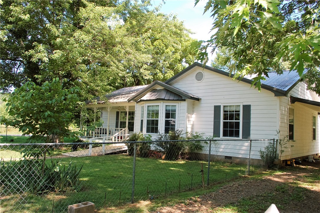 Very comfortable 3 bedroom, 1 large bath home.   Large, open  living/ dining area.  Bay window.  Cozy covered front porch, covered deck off the rear of the home.  Completely fenced, Large storage building behind the home.  Some gorgeous plants in the back yard.  Central heat and air.  Well maintained home in a quaint little town.  Call me to see this home.