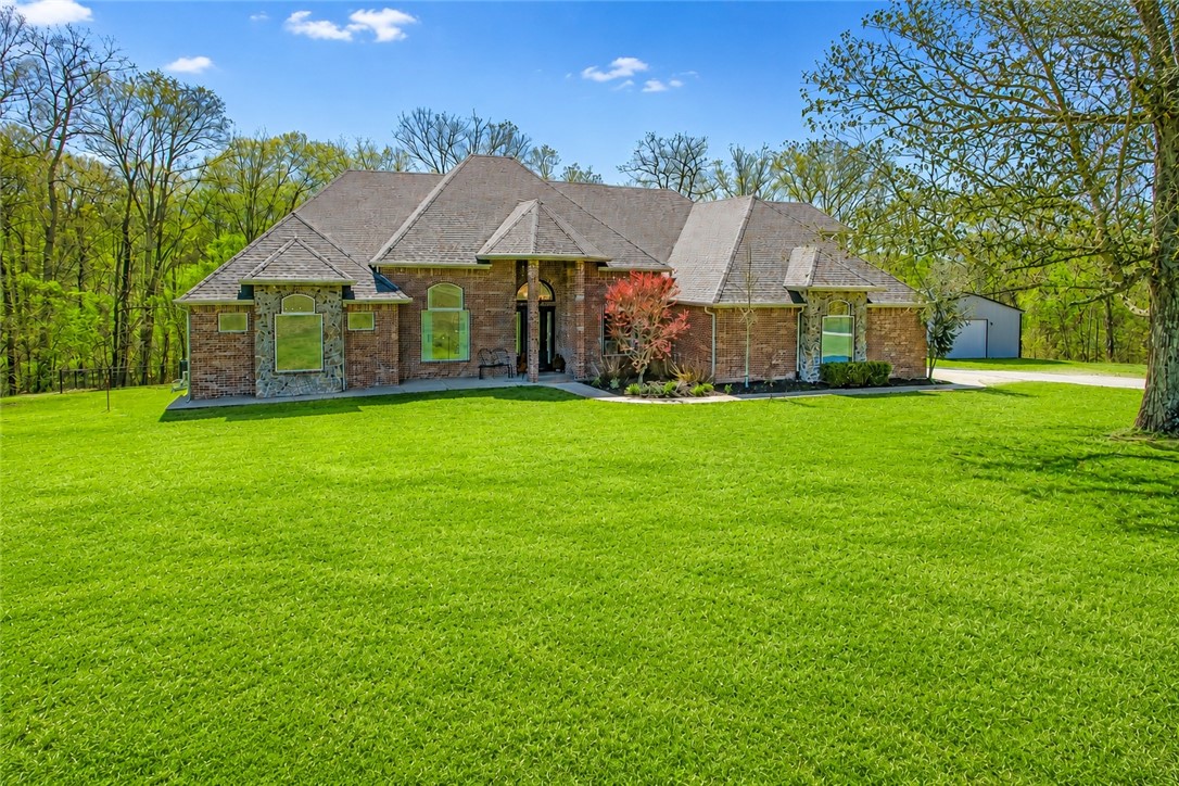 Experience the perfect blend of luxury, space, & privacy on 7.6 acres, approx. 15 minutes from downtown Bentonville. This home offers 5 bedrooms, an office, each main-level bedroom with its own private bath, & two living areas. The primary suite features a sitting area, dual-sided fireplace, & spa-style bath. Designed for everyday living & entertaining, the home includes two living areas, a bright sunroom, & a spacious kitchen with granite countertops. Step outside to enjoy the in-ground pool with waterfall, diving board, & deck overlooking the pool.  Recent improvements include interior paint (2026), updated lighting, new flooring, remodeled office bath, new pool pump, HVAC (2024), & a 2023 roof. The home also features a newly built 30x40 shop with finished living space, including kitchen, living area, bedroom, bathroom, laundry, & upstairs storage, ideal for guests or multigenerational living. A rare opportunity to own a beautiful property with acreage, pool, and guest house with shop.