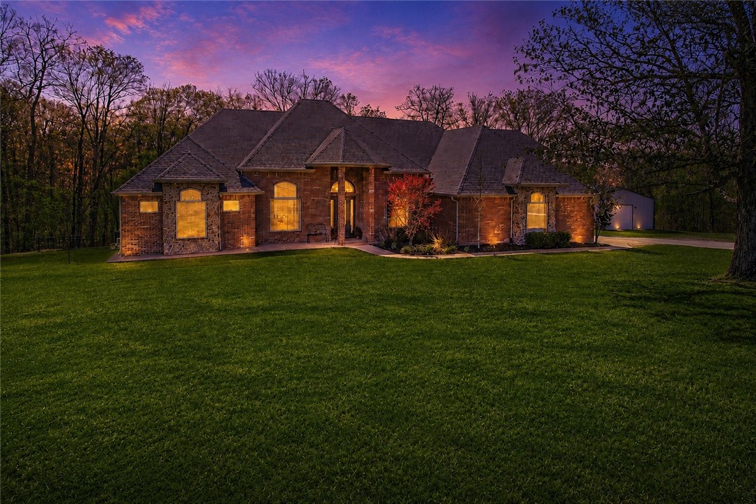 Experience the perfect blend of luxury, space, & privacy on 7.6 acres, approx. 15 minutes from downtown Bentonville. This home offers 5 bedrooms, an office, each main-level bedroom with its own private bath, & two living areas. The primary suite features a sitting area, dual-sided fireplace, & spa-style bath. Designed for everyday living & entertaining, the home includes two living areas, a bright sunroom, & a spacious kitchen with granite countertops. Step outside to enjoy the in-ground pool with waterfall, diving board, & deck overlooking the pool.  Recent improvements include interior paint (2026), updated lighting, new flooring, remodeled office bath, new pool pump, HVAC (2024), & a 2023 roof. The home also features a newly built 30x40 shop with finished living space, including kitchen, living area, bedroom, bathroom, laundry, & upstairs storage, ideal for guests or multigenerational living. A rare opportunity to own a beautiful property with acreage, pool, and guest house with shop.