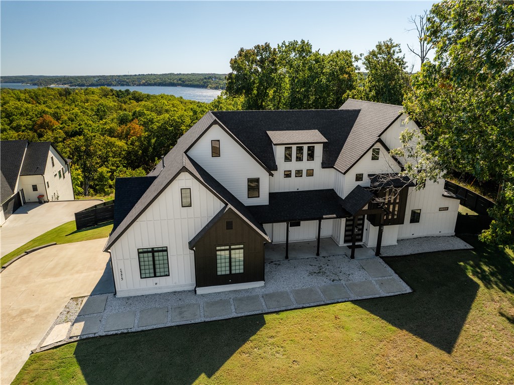 Experience modern luxury and thoughtful design in this stunning 3,991sf custom-built home, completed in 2021 and perfectly situated on 1.36 acres. This move-in ready residence offers 4 bedrooms, 3.5 baths, blending open-concept living with refined finishes throughout. The chef's kitchen is a showpiece, featuring a 48" gas range with custom vent hood, quartz countertops, two spacious islands, a pot filler, abundant custom cabinetry, and a large walk-in Butler's pantry. The main level includes two bedrooms (including primary) and convenient dog bath in the laundry area. Upstairs are two additional bedrooms and a bonus room offering flexible living options for guests or family. There is a secondary bonus room w/a hidden room which can serve many options. Outdoor living shines with a covered back patio and outdoor kitchen w/refrigerator, 26" grill w/rotisserie, Traeger smoker, hot tub, fire table, & rooftop deck w/lake views. 32' boat slip w/hydryhoist lift included.