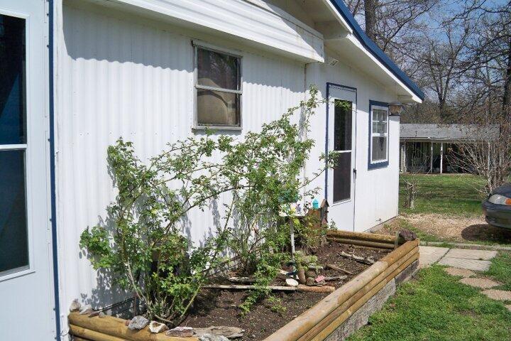 Adorable mobile home that's been added onto on a little over half acre property consisting of 3 lots. The house is 4 bedrooms, 1.5 baths with enclosed patio.
