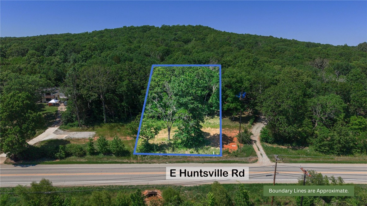 Tucked along highly traveled Huntsville Road with excellent road frontage, this 0.78-acre wooded lot is a rare opportunity to build in one of Fayetteville's most accessible corridors. With mostly wooded coverage and a gently sloping, south-facing terrain, the natural setting provides both privacy and charm. Public water, sewer, electric, and gas are all available at the street, making development refreshingly straightforward. Zoned residential with no flood zone concerns and no covenants, you'll have the flexibility to bring your vision to life. Best of all, you're just minutes from the University of Arkansas campus and the vibrant shops, dining, and entertainment of downtown Fayetteville. Whether you're building your dream home or looking for a smart investment in a booming market, this lot checks all the boxes. Come take a look — opportunity like this doesn't last long in NW Arkansas!