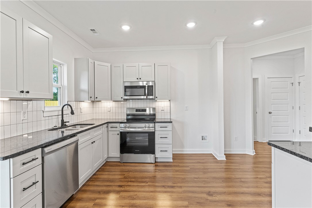 Up to $16,000 down payment assistance for qualified buyers. This property is also RD Eligible! Beautiful floor plan featuring two large bedrooms and office with additional closet space in the hallway. You’ll love the luxury vinyl plank floors and gorgeous tile. Large kitchen has gorgeous soft-close cabinets and brushed granite counters. Under-cabinet lights brighten the beautiful backsplash and you’ll love the storage space in the cabinets and the wrap around bar, plus nice-sized pantry for food and prep storage! The natural light from the patio doors open to a covered patio in the back. Your favorite kitchen table and buffet have plenty of room! Living area is open and convenient so you’ll not miss anything while entertaining! Primary suite has plenty of space for your oversized furnishings. Primary suite bath has a beautiful tile, walk-in shower and a huge closet with built-ins! The large corner lot is flat for gardening or privacy fence. You will love the 10X10 concrete patio for entertaining!