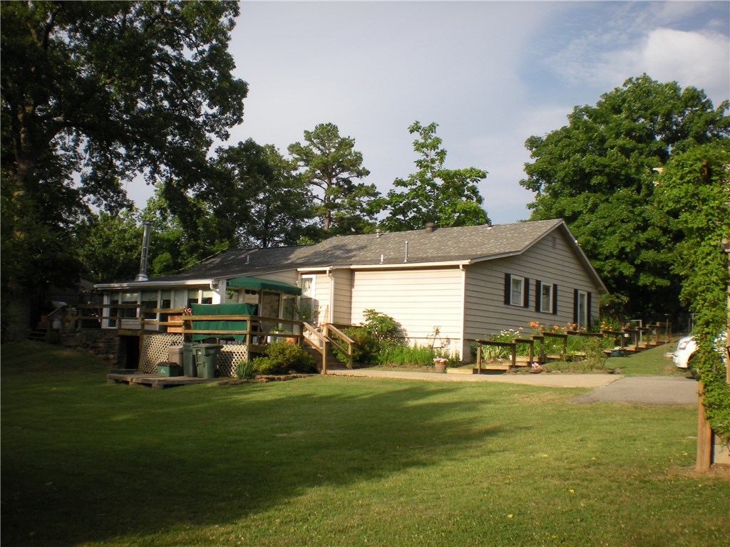 Location!!! Right in the heart of Fayetteville, this home has tons of potential! Huge landscaped lot with flowers, shrubs & plenty of room to grow! Close to downtown square, Dickson St. Big rooms include 2 living areas, huge kitchen, massive master bedroom! Some updates already done.  Big sunken living/sun room w/wood stove (will convey @full price), storm shelter, gorgeous pergola, great deck. Home sold "as is" but is close to being your dream home! Zoned RSF-4.