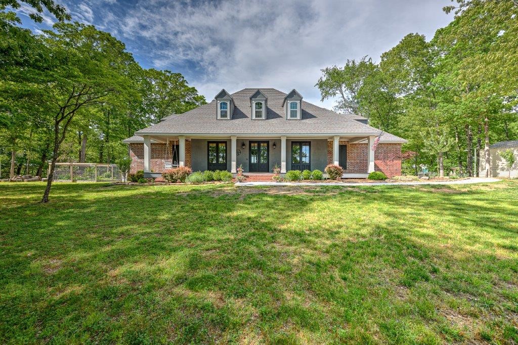 MOVE IN READY! GORGEOUS lake home w/ stunning lake views and Boat Slip! Your PARADISE awaits in this Southern Living styled home overlooking Beaver Lake. Beautiful luxury home with large windows, on a paved road. Home boasts amazing updates throughout including new flooring, paint, appliances and more!  Well-appointed chef's kitchen with Jenn Air gas cooktop with large eat in breakfast area enjoying a spectacular lake view. Formal dining room, private office, living room with a vented gas fireplace. The owner's suite features lake views, fireplace, beautiful en suite bath and access to fabulous screened porch.  2nd level hosts 3 bedrooms, 2 baths & a large bonus room.  Screened porch enjoys amazing lake views!  2 laundry rooms! Generac home generator, 700 sq ft insulated workshop w/ new 750 sq ft attached 2 car garage for storage!  Large carport w/ electricity! 6 garage spaces! Home will be sold partially furnished. Boat slip (28’ x 9’10”) w/ lift in community dock. Property includes 4 lots to ensure amazing views!