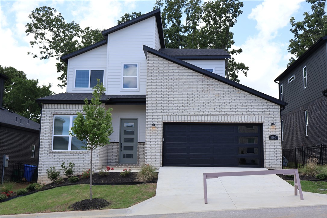 Step inside from the covered front porch into a bright, open layout with 10-foot ceilings on the main floor, hardwood flooring, and clean modern details. The main living area has a stunning fireplace with vertical tile surround, a warm stained wood mantel. The great room flows seamlessly into the kitchen and dining areas, creating an inviting layout for everyday living and entertaining.
The kitchen features a large center island, modern cabinetry, sleek finishes, and Frigidaire Professional stainless steel appliances.
The main-level primary suite is designed as a private retreat with decorative stained ceiling beams, hardwood flooring, and a spacious layout. The primary bath includes a freestanding soaking tub, walk-in tile shower with glass enclosure and dual vanities. A dedicated study with glass French doors, built-in cabinetry and floating shelves. 
Outdoor living is easy with both a covered front porch and a covered back patio overlooking the backyard.
