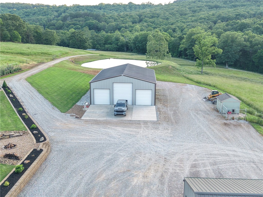 Escape to your own private retreat in NWA. Property features 10 beautiful acres that blends peaceful country living with modern convenience! The inviting 3 bed 2 bath 1400 sq ft home features custom cabinetry, a warm, functional layout designed for comfortable everyday living. 6 in exterior walls, spray foam insulation and triple pane windows make this home energy efficient helping to keep utility costs low year-round. A 2 car detached garage provides additional storage and parking. The standout feature is the impressive 40x60 insulated shop, with 5 bays and half bath, ideal for storing equipment, running a business, working on projects or storing your recreational toys! Outside, the property truly shines. Fish in the fully stocked pond, sitting around the fire pit, gathering berries from more than 2 dozen Triple Crown thornless blackberry bushes or exploring the wet weather creek running through the property. Property has 50 amp RV hookup. 40 additional acres available! 30-45 minutes to most surrounding towns.